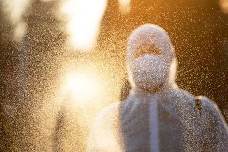 Man in protective equipment decontaminating and spraying on a public place as a prevention against Coronavirus disease 2019, COVID-19. Coronavirus pandemic.の写真素材