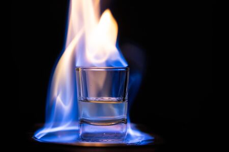 Glasses with burning alcohol on black background.の写真素材