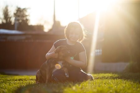 Little cute toddler girl hugging her dog. Kid and animal friendship concept.の写真素材
