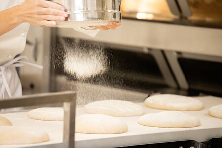 Baker working in bakery making tradition french bread and pastry.