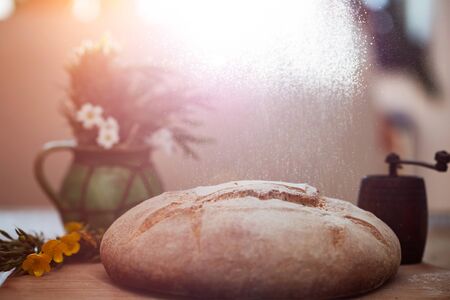 Freshly baked wheat bread on wooden cutting board. Still life with home made rustic bread.