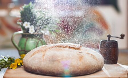 Freshly baked wheat bread on wooden cutting board. Still life with home made rustic bread.の写真素材