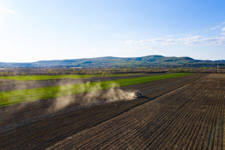 Aerial drone view of tractor working on agriculture spring field.の写真素材