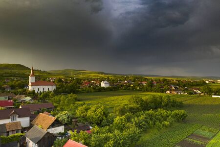 Dramatic sky with thunderstom over small village in Transylvania.の写真素材