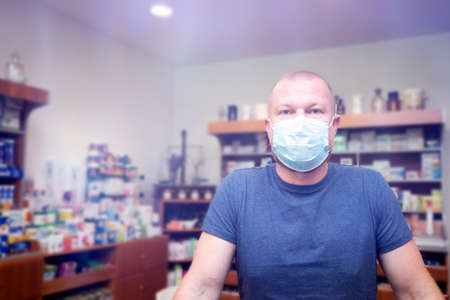 Pharmacist with protective mask due to coronavirus pandemic ,working at pharmacy. Medical healthcare concept.の写真素材