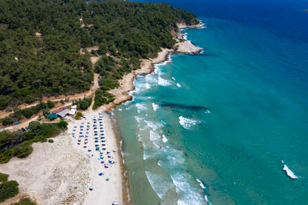 Aerial view of sandy beach with swimming people in sea bay with transparent blue water in summer. Travel in Thassos Island, Greece.の写真素材