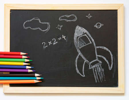 Back to school concept with hand drawn rocket on blackboard and school supplies. Flat lay.の写真素材