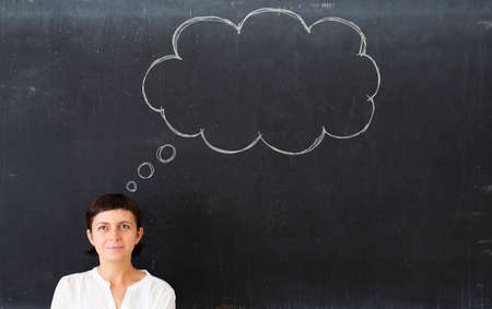Hand drawn speech bubble on blackbord, casual business woman looking at it. Creative idea and...