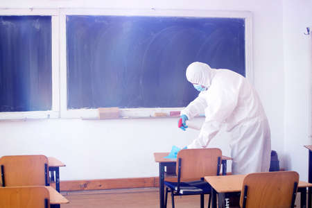 Worker sprays disinfectant as part of preventive measures against the spread of the COVID-19, the novel coronavirus in schools. Preparing for the new school season.の写真素材