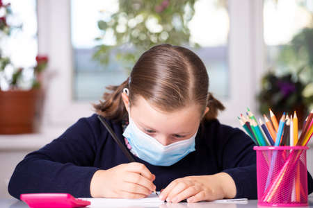 School child wearing mask for protection against coronavirus in school. Measures to prevent the spread of COVID-19 at schools during coronavirus pandemic.の写真素材