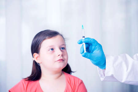 Children vaccinating immunization concept. Doctor injecting vaccination in arm of a little girl.の写真素材