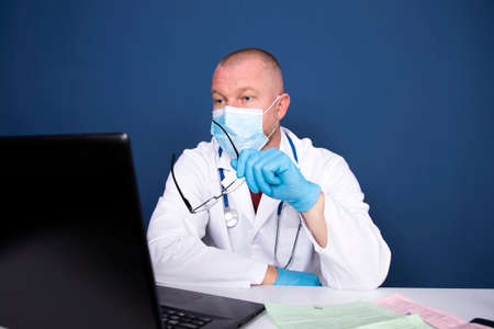 Male doctor consulting patient by online video call on laptop. Remote online medical chat...