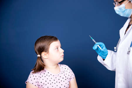 Children vaccinating immunization concept. Doctor injecting vaccination in arm of a little girl with...