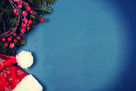Vintage photo of Red Santa Claus hat on blue background with copy space. Flat lay, top view.の写真素材
