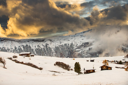 Small cottage in magic sunset in Dolomite mountains, Alpe di Siusi, Italy in winterの写真素材