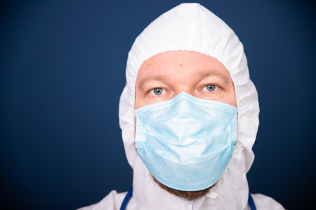 Coronavirus concept. COVID-19. Male doctor in protective suit uniform - close-up portrait.の写真素材
