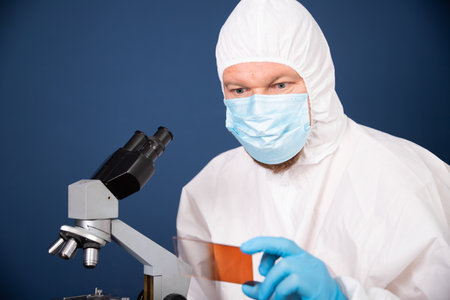 Scientist looking through a microscope for coronavirus vaccine development in pharmaceutical...