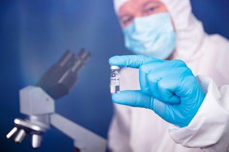 Coronavirus, covid-19 vaccine in hands of pharmacuetical bio research scientist in vaccine development laboratoryの写真素材