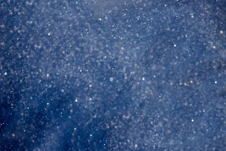 Magic Christmas and holiday background with falling snow and bokeh.の写真素材