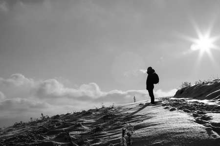 Lonely traveller silhouette in snowy mountains at winter.の写真素材
