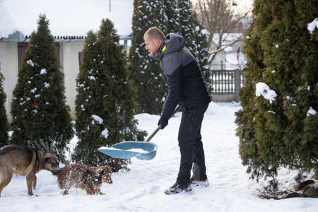 Man cleaning snow with shovel in winter day.の写真素材