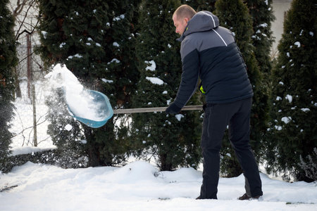Man cleaning snow with shovel in winter day.の写真素材