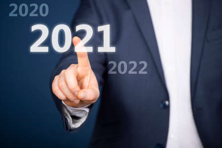 Businessman pressing on 2021. New Year concept.