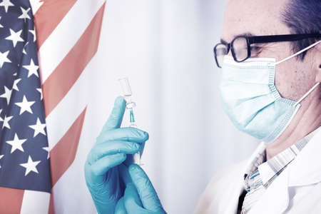 USA flag with doctor preparing for vaccine. Mass vaccination against the epidemic in USA  concept.
