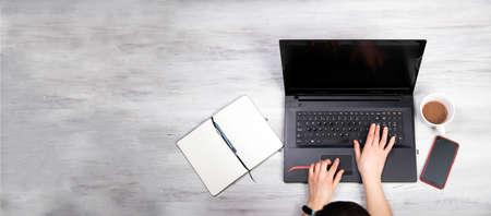 Top view of person working on a laptop computer