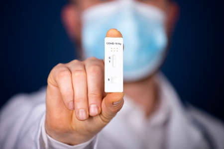 Doctor holding a test kit for viral disease. Lab card kit tested NEGATIVE for viral novel virus.