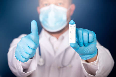 Doctor holding a test kit for viral disease COVID-19. Lab card kit tested NEGATIVE for viral novel...