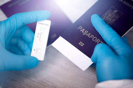 Doctor holding passport and negative covid-19 ( rapid antigen SARS-CoV-2 Ag ) test. Coronavirus and...