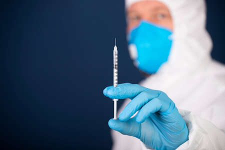 Concept of herd immunity, virus spreading in society. Doctor with syringe is preparing for vaccine.
