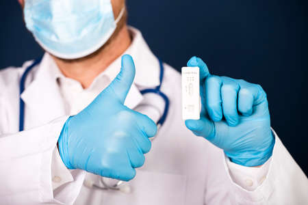 Doctor holding a test kit for viral disease COVID-19. Lab card kit tested NEGATIVE for viral novel...