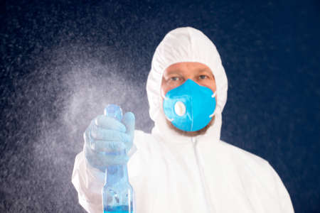 Conavirus pandemic. Man in full protected suit with disinfectant for prevention and control of epidemic.の写真素材