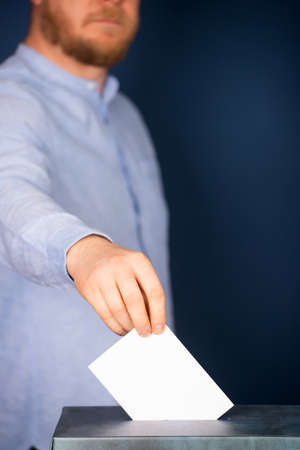 Hand of a voter putting vote in the ballot box. Election concept.の写真素材