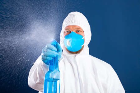 Conavirus pandemic. Man in full protected suit with disinfectant for prevention and control of epidemic.の写真素材