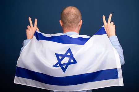 Israeli patriot holding the flag of Israel on his shouldersの写真素材
