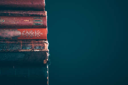 Literature, reading concept: banner or header image with stack of antique books against a dark...