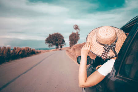 Young woman traveling in a car across Europe. Freedom, travel and vacation road trip concept...