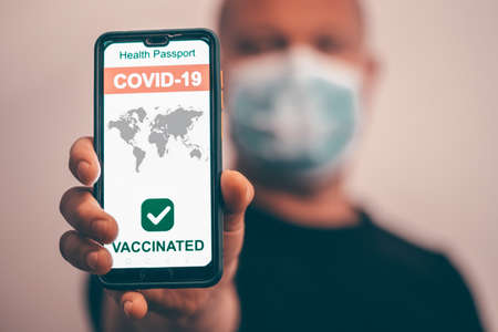 Smartphone with valid digital vaccination certificate COVID-19.Immunity passport, health and surveillance concepts.の写真素材