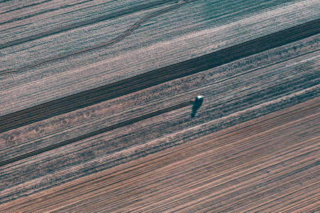 Aerial drone view of tractor working on agriculture spring field.の写真素材