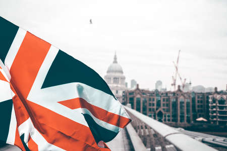 Union Jack flag and iconic London landmarks in the backgroundの写真素材