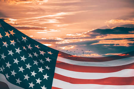 Celebrating Independence Day. United States of America USA flag over sunset sky, background for 4th of Julyの写真素材