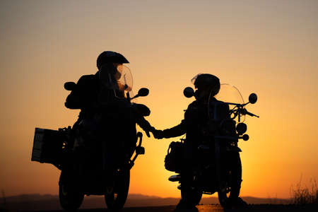 Motorcycle couple in sunset with classic motorcycleの写真素材