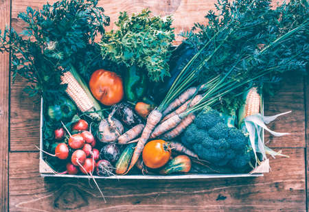 Flat lay of fresh bio vegetable in a wooden box. The concept of healthy food.