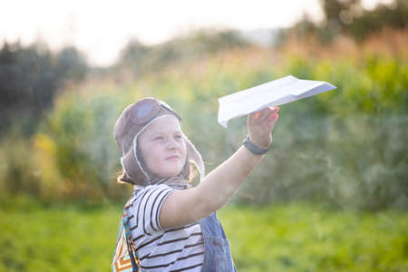 Happy kid playing in pilot helmet pretend to be aviator. Travel, vacation and freedom concept....
