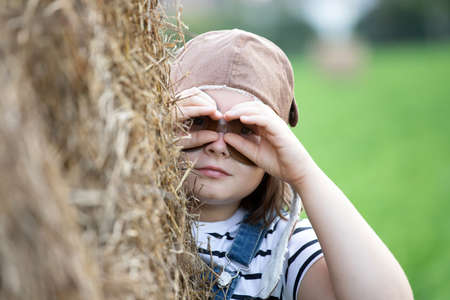 Happy kid playing in pilot helmet pretend to be aviator. Travel, vacation and freedom concept. Childhood, imagination, dream.の写真素材