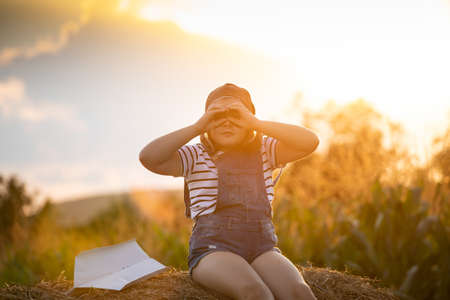 Happy kid playing in pilot helmet pretend to be aviator. Travel, vacation and freedom concept. Childhood, imagination, dream.の写真素材