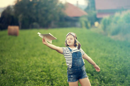 Happy kid playing in pilot helmet pretend to be aviator. Travel, vacation and freedom concept....